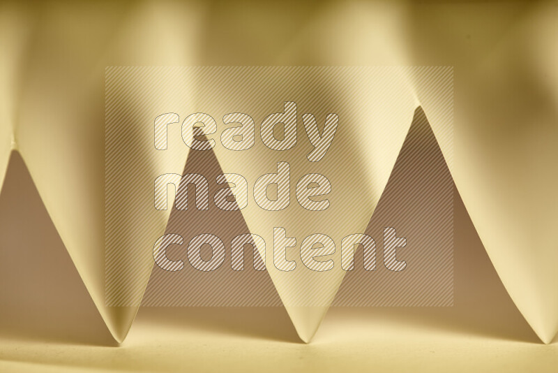 صورة مجردة مقربة تظهر طيات ورقية هندسية حادة بتدرجات الوان دافئة