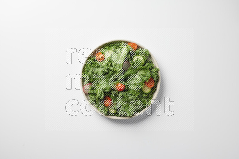A bowl of fresh vegetables salad with kale leaves, cherry tomatoes, sliced radishes and sliced cucumber on a white background