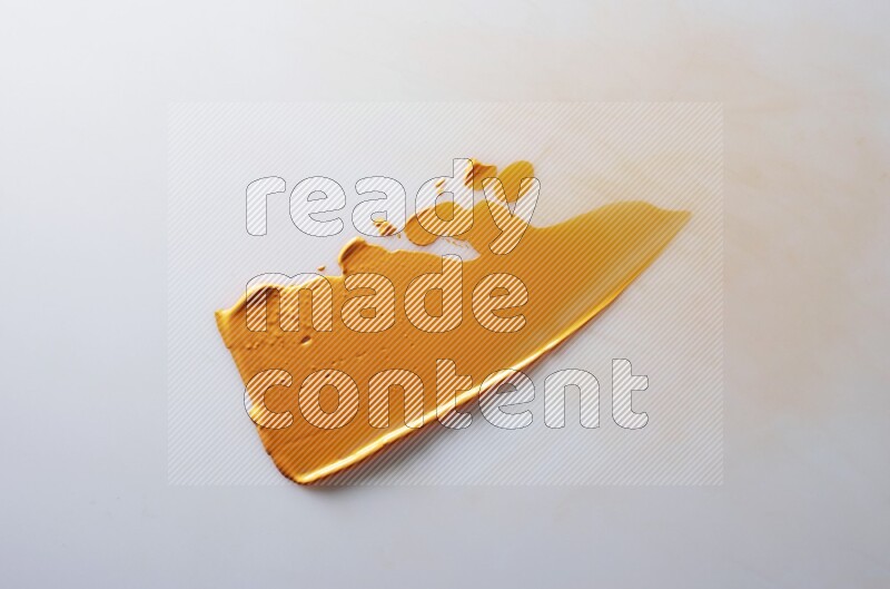 An orange single curved painting knife stroke on white background