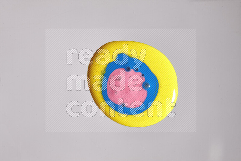 لقطات مقربة لألوان متنوعة تمتزج على خلفية رمادية