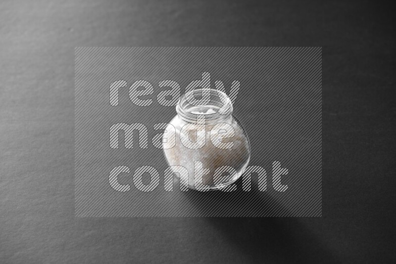 ملح في وعاء زجاجي علي خلفية سوداء