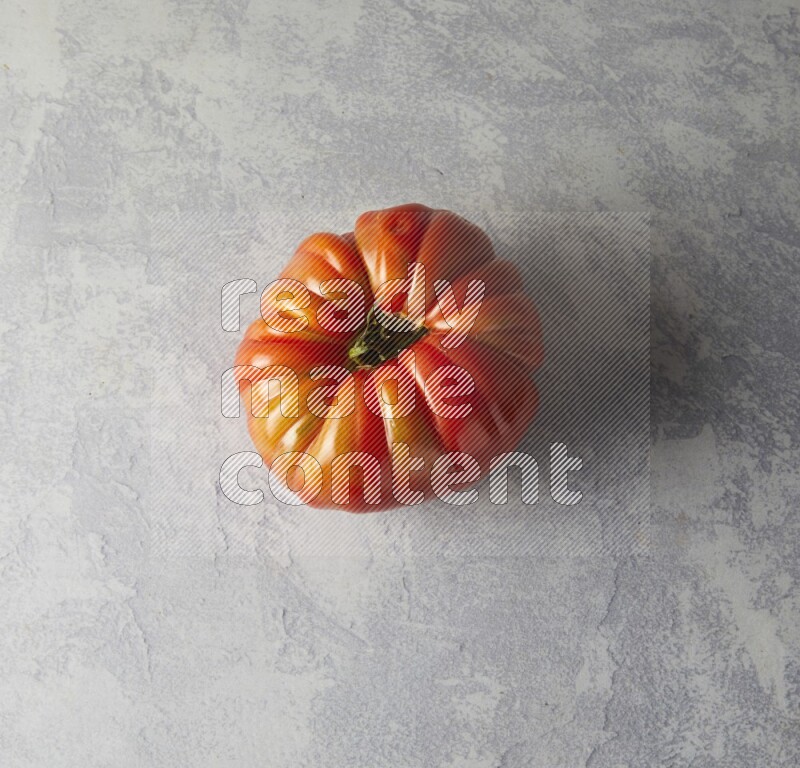 Single Topview Heirloom Tomato on a sky blue background