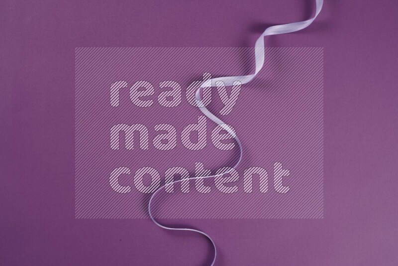 A purple collection of sewing and tailoring tools arranged on a purple background