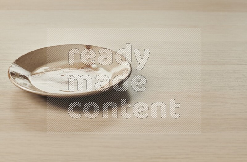 A multicolored pottery plate on light wooden background