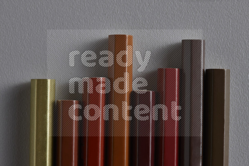 مجموعة من أقلام الرصاص الملونة مرتبة لتعرض تدرجا من الألوان البنية علي خلفية رمادية