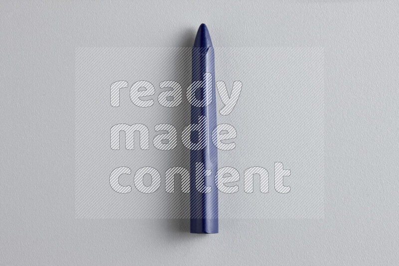 A close-up showing a single wax crayon on grey background