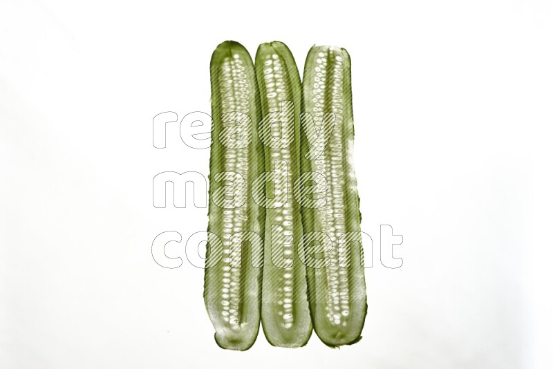Cucumber slices on illuminated white background