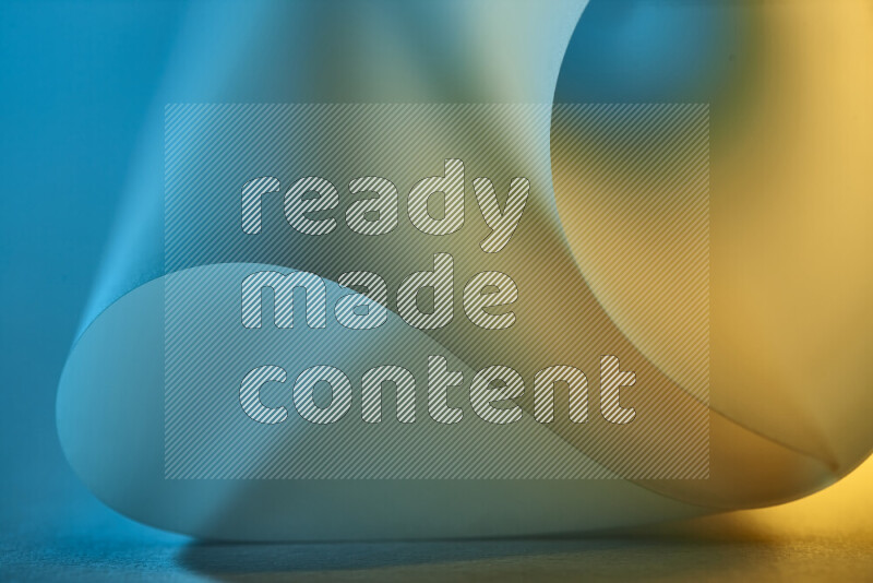 An abstract art piece displaying smooth curves in blue and gold gradients created by colored light