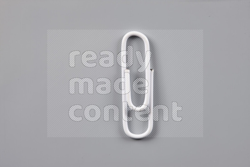 White paper clips isolated on a grey background
