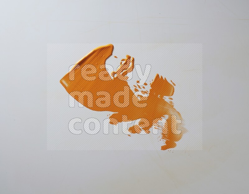 An orange single random painting knife stroke on white background