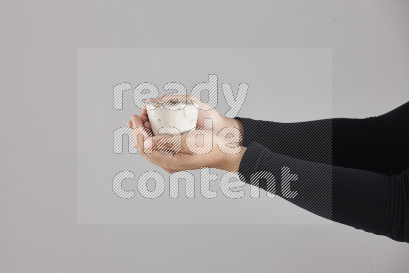A woman in black abaya holding different pottery essentials in different positions