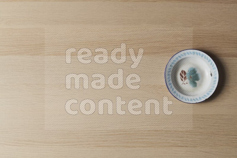 A vintage metal plate on light wooden background