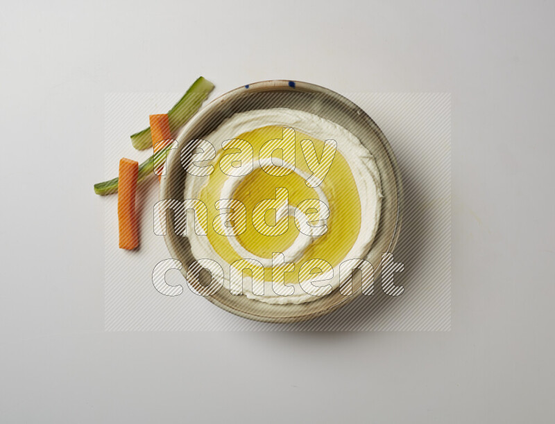 Lebnah garnished with olive oil in a grey pottery plate on a white background
