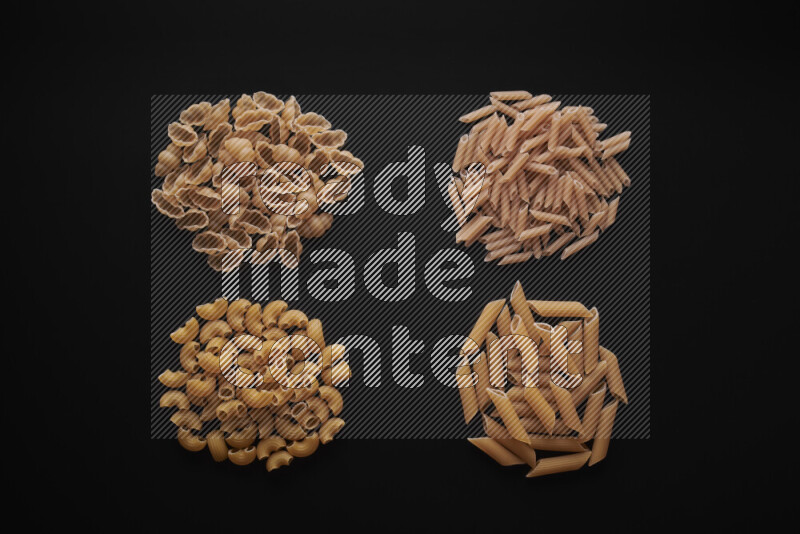 Different pasta types in bunches on black background