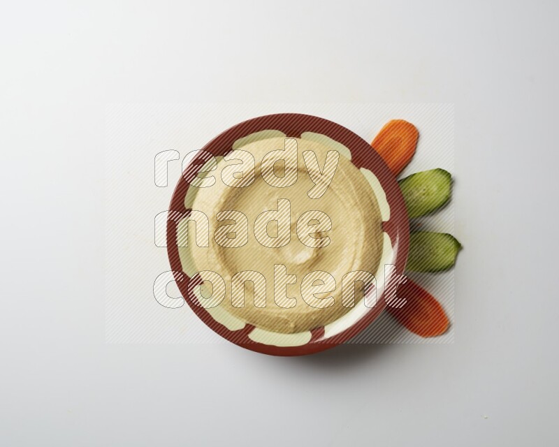 Plain hummus in a traditional plate on a white background