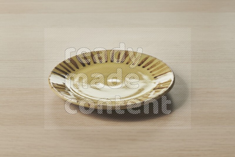 A multicolored pottery plate on light wooden background