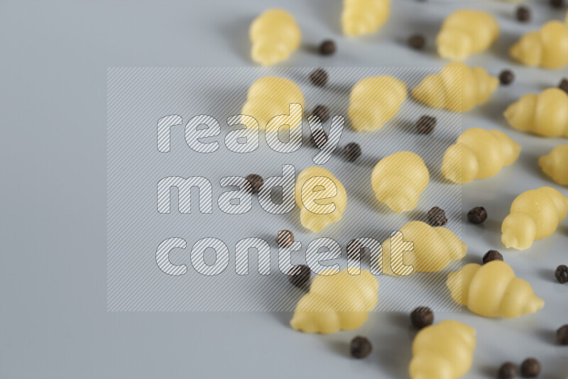 معكرونة مع مكونات متنوعة من الطماطم والثوم والبصل والفلفل الأحمر والفلفل الأسود والفلفل الأبيض وأوراق الغار وإكليل الجبل والهيل و مشروم على خلفية زرقاء فاتحة