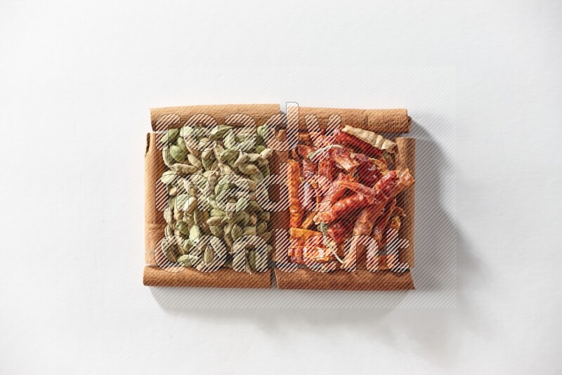 2 squares of cinnamon sticks full of cardamom and dried red chilis on white flooring