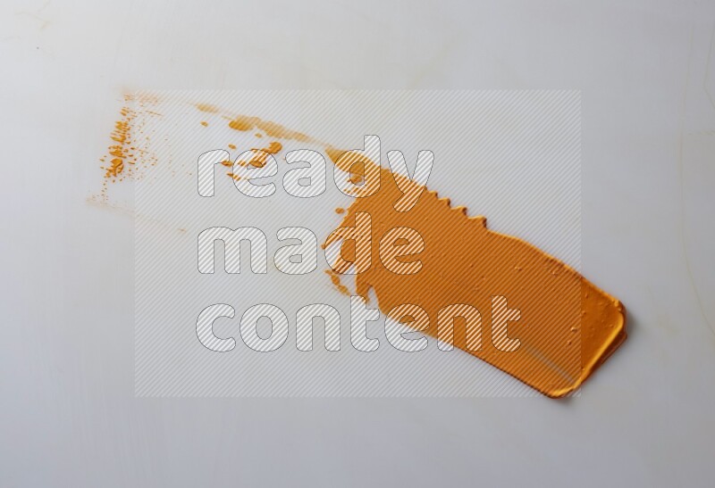 An orange straight painting knife stroke on white background