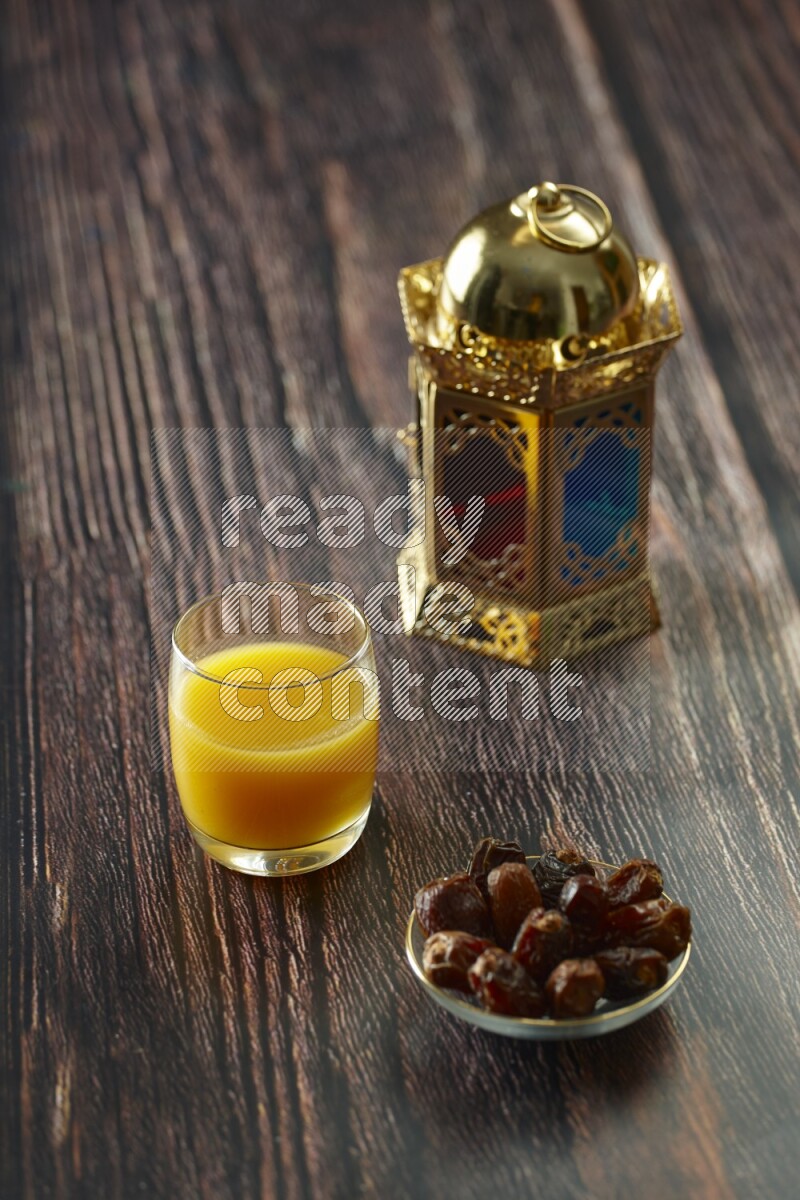 A golden lantern with different drinks, dates, nuts, prayer beads and quran on brown wooden background