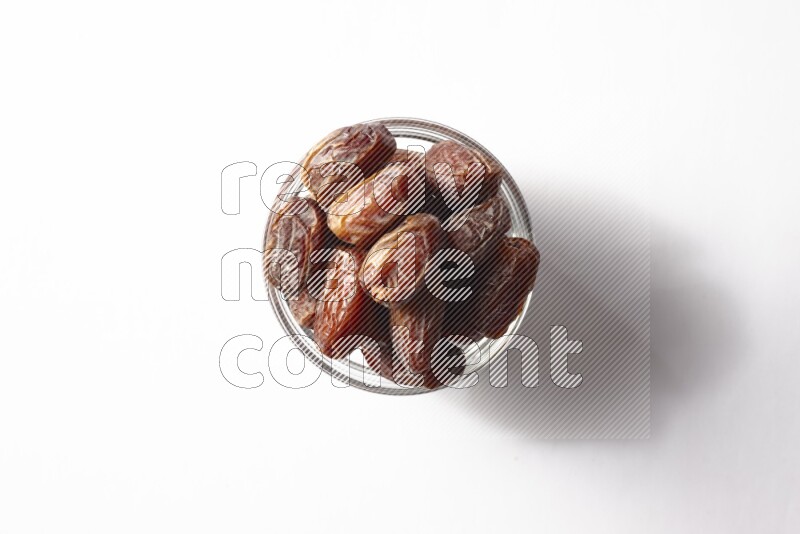 Dates in a glass bowl on white background