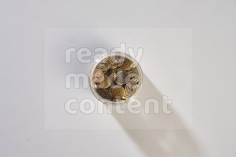 Colored buttons in a glass jar on grey background