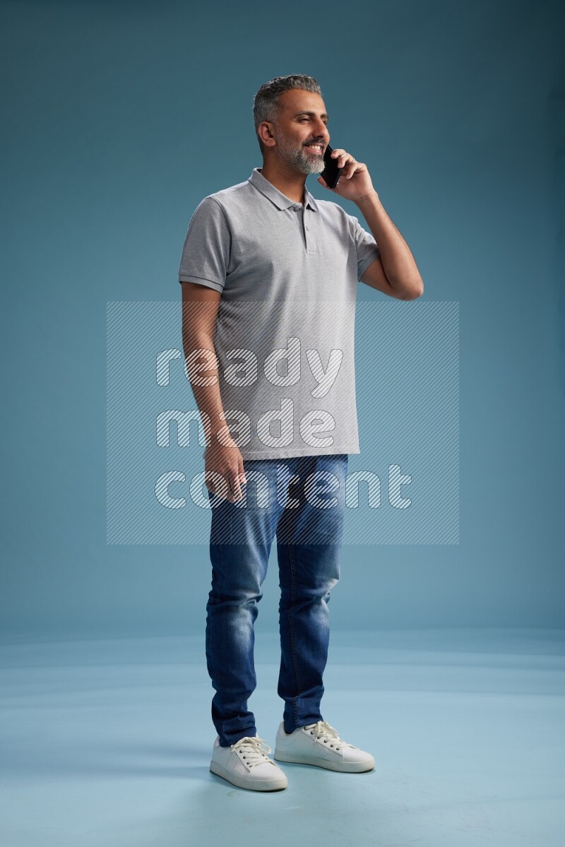 Man Standing talking on phone on blue background