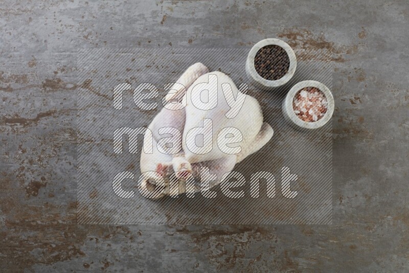 whole raw chicken  direct on a rustic grey background