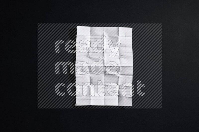 Folded notebook sheet on black background