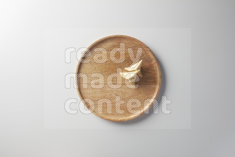 Two Sambosas on a wooden round plate on a white background