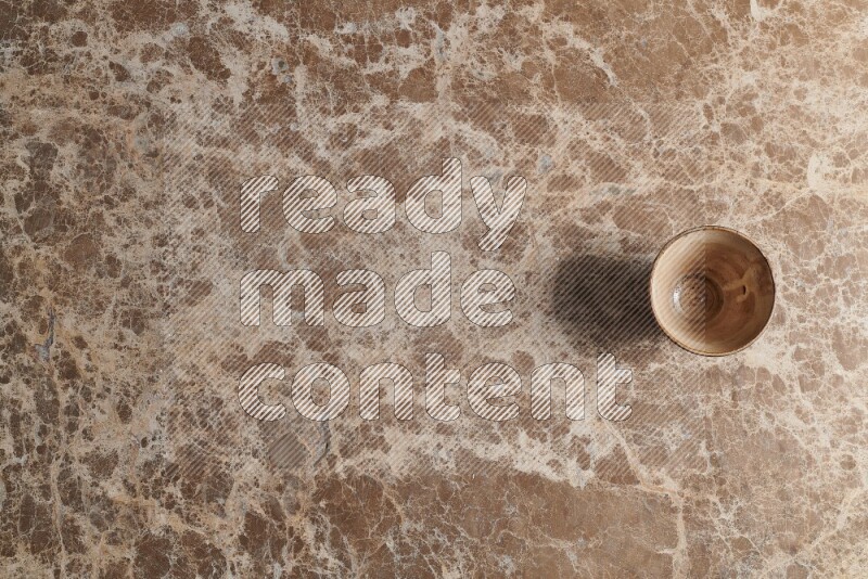 A pottery cup on beige marble background