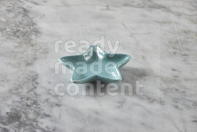 A colored pottery star plate on grey marble background