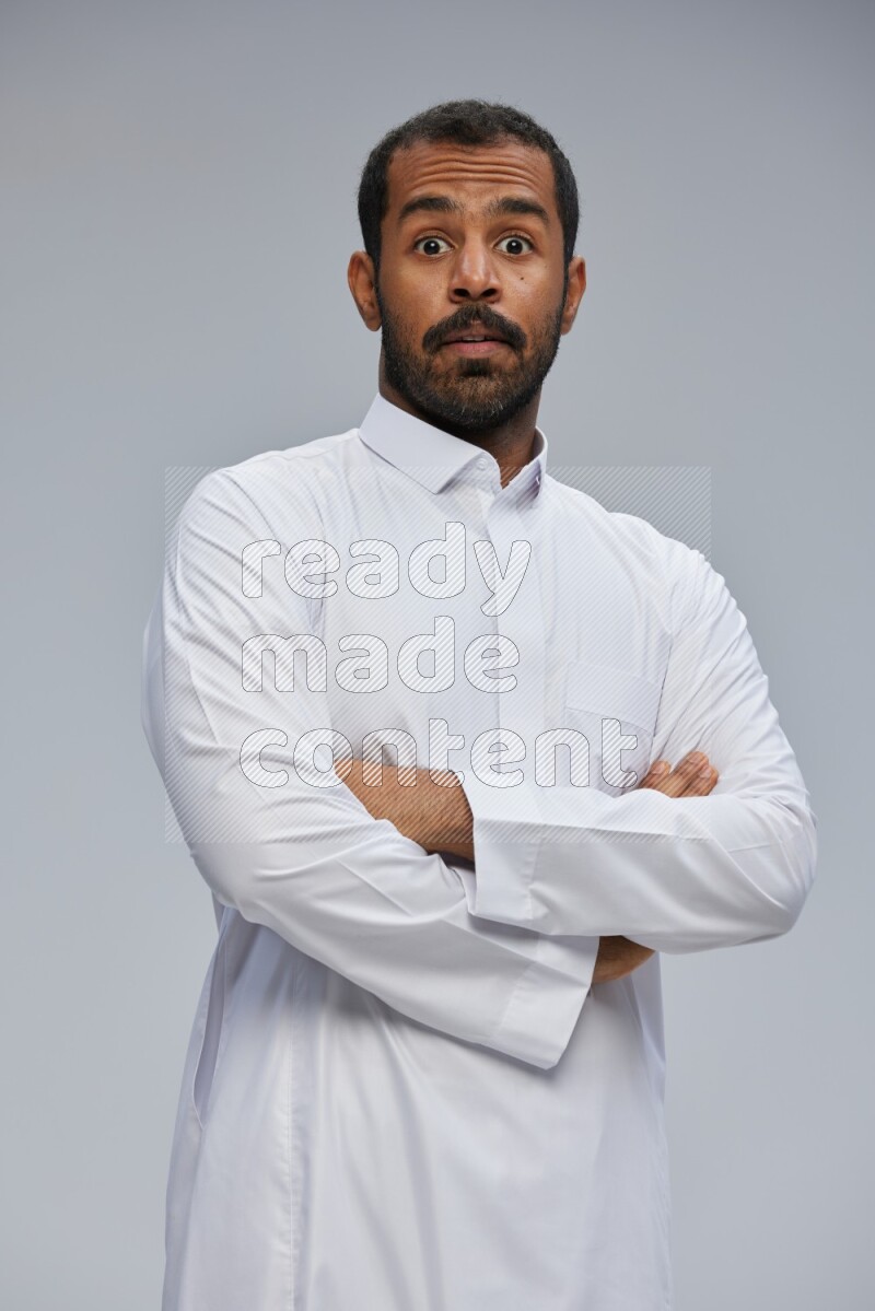 Saudi man wearing Thob standing with crossed arms on Gray background
