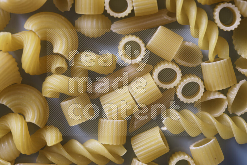 Different pasta types on light blue background