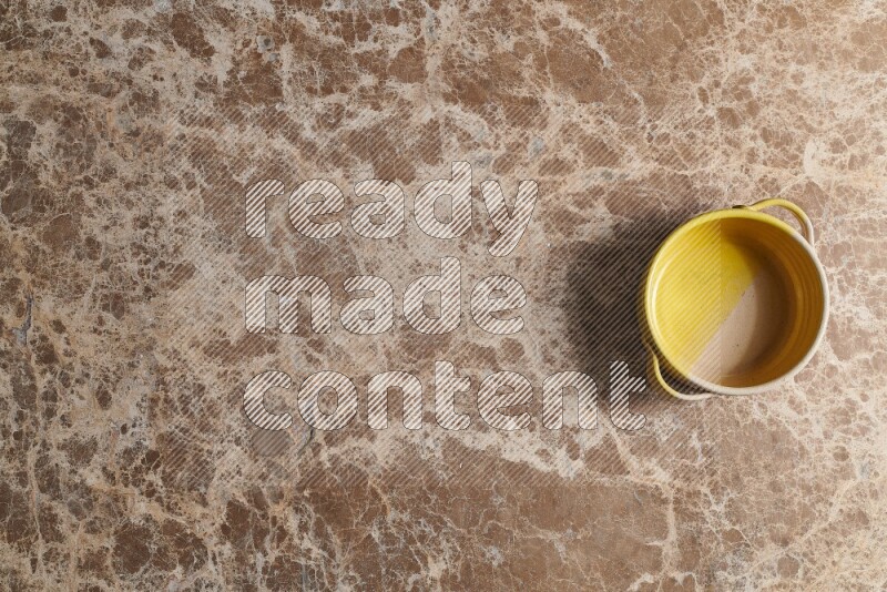 A multicolored pottery bowl on beige marble background