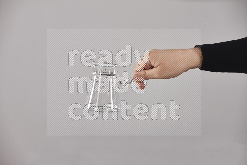 امرأة ترتدي عباءة سوداء تحمل أدوات زجاجية مختلفة في أوضاع متعددة