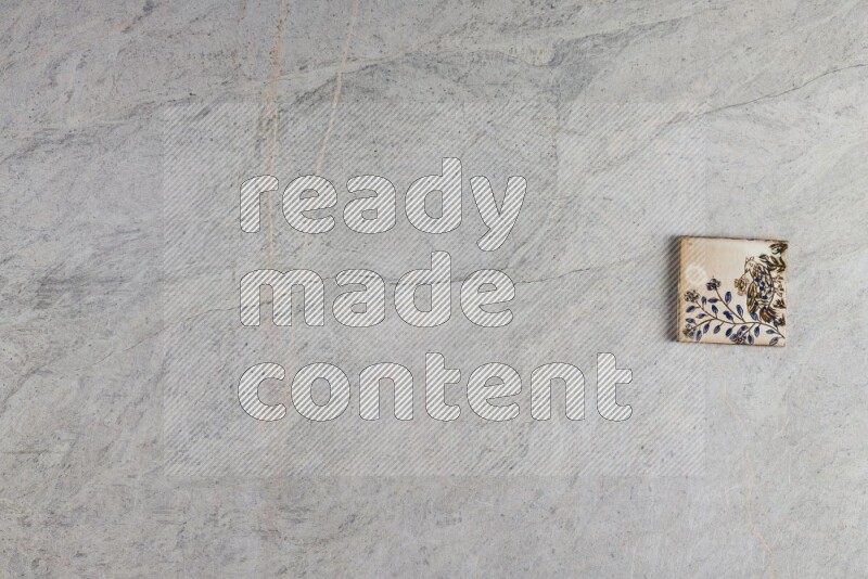 A decorative pottery coaster on grey marble background