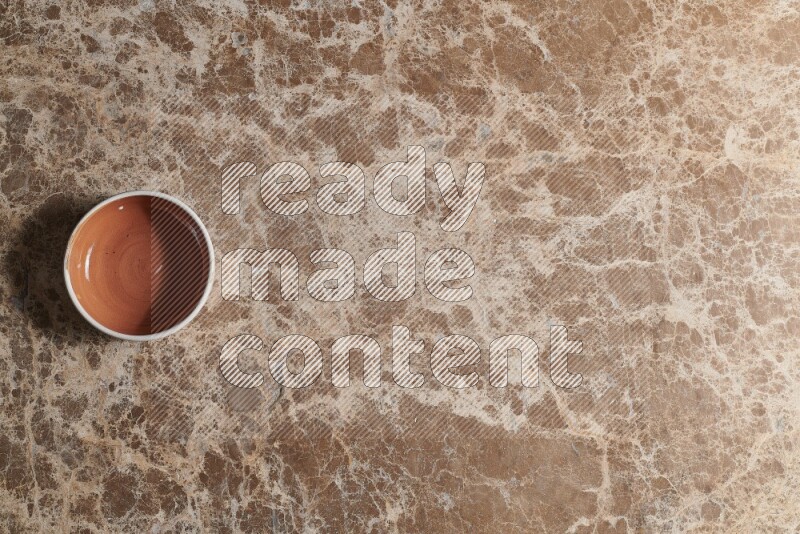 Top View Shot Of A Brown Pottery bowl On beige Marble Flooring