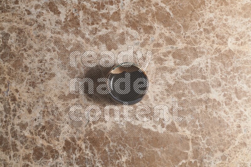 A multicolored pottery bowl on beige marble background