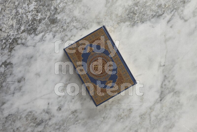 Quran with a prayer beads on grey marble background