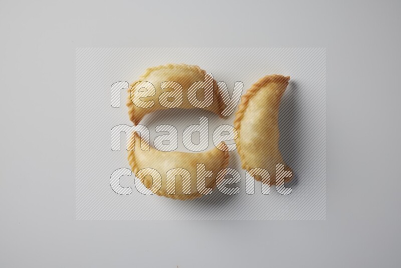 Three fried sambosa from a top angle on a white background