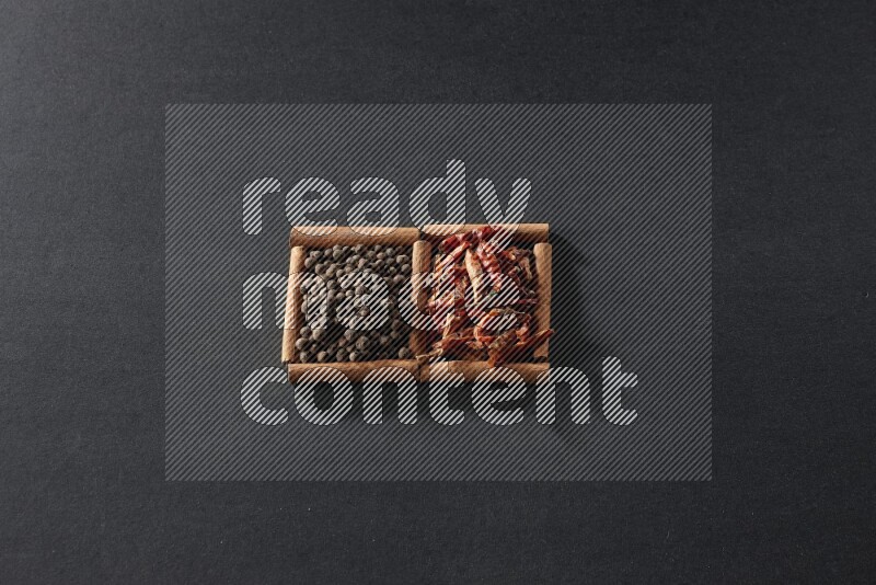 2 squares of cinnamon sticks full of chilis and allspice on black flooring
