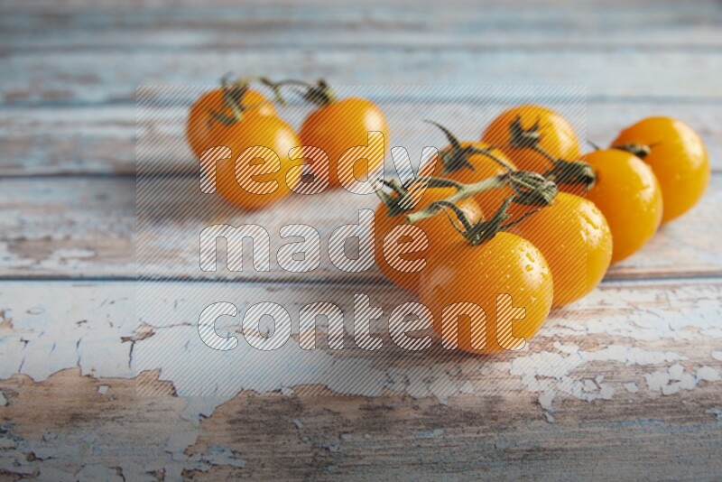 yellow cherry tomato vein on a textured blue wooden background 45 degree