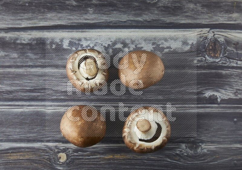 small fresh Cremini wood mushrooms topview on grey wooden textured background