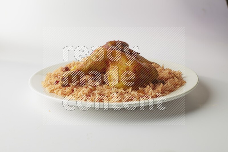 red basmati Rice with kabsa chicken pieces on a white rounded plate direct on white background