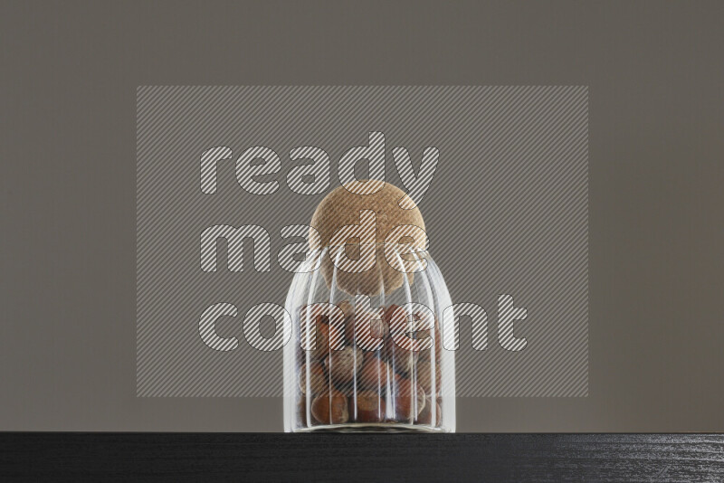 Hazelnuts in a glass jar on black background