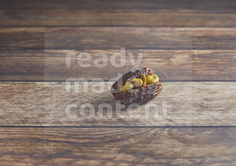 pistachio stuffed madjoul date on a wooden background
