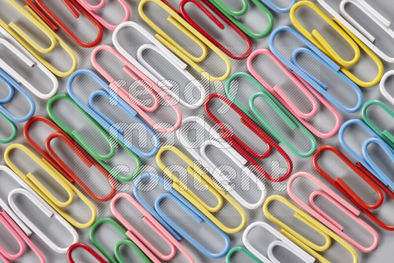 Multicolored paper clips isolated on a grey background