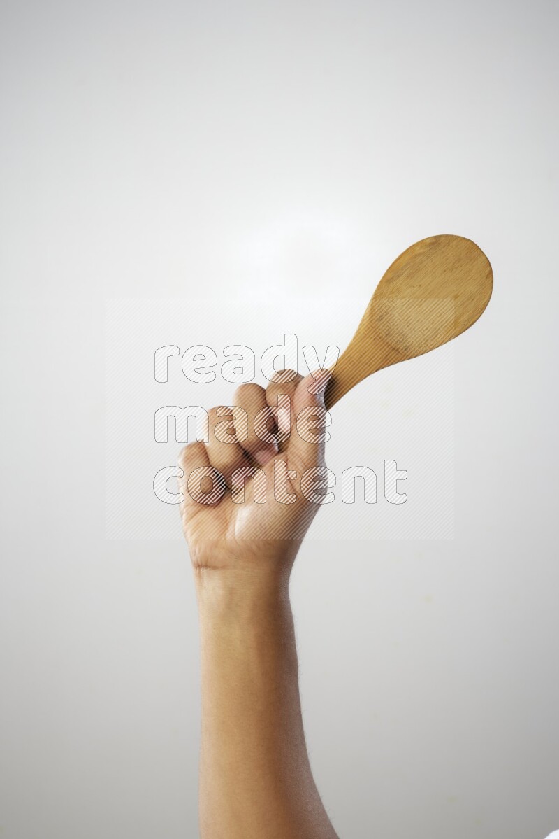 Male Hand Holding Wooden spoon on white background