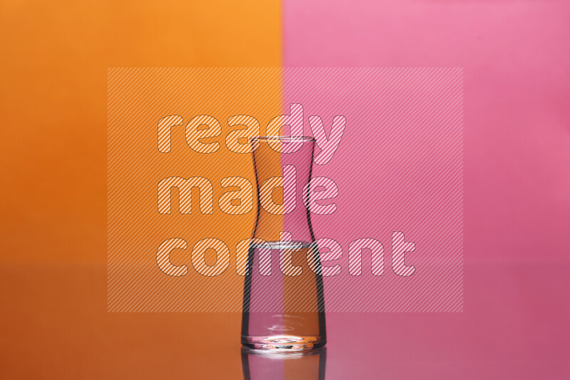 The image features a clear glassware filled with water, set against orange and pink background